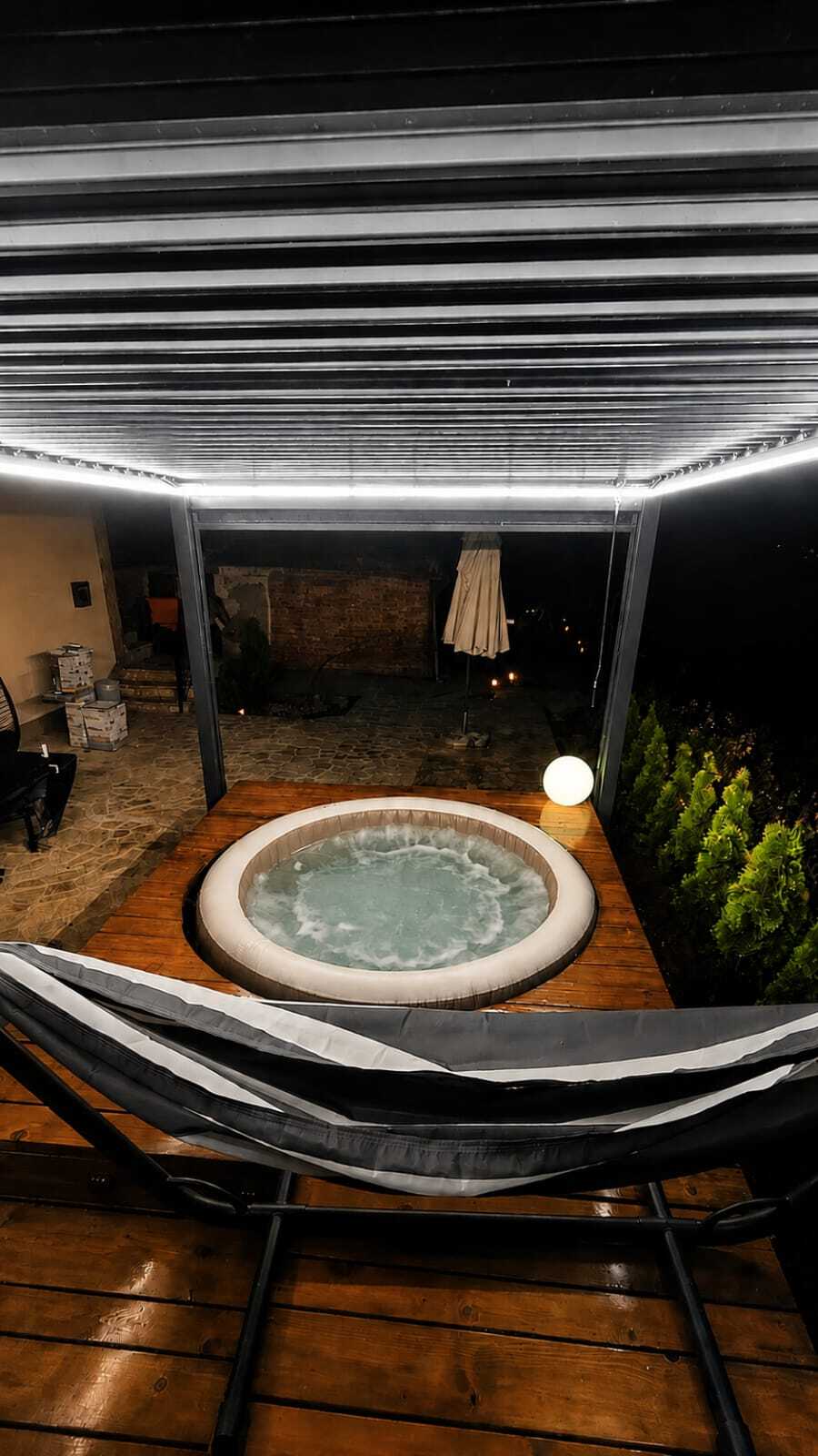 Jacuzzi noću pod natkrivenom pergolom